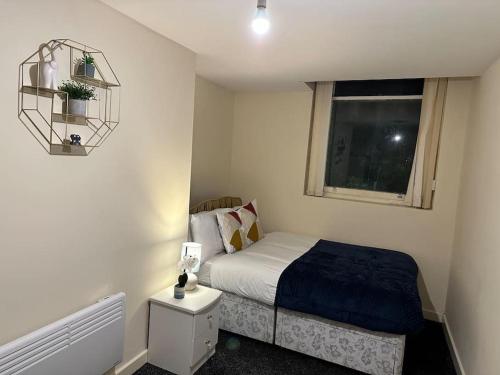 a small bedroom with a bed and a window at Airrose two bed apartment in Wolverhampton
