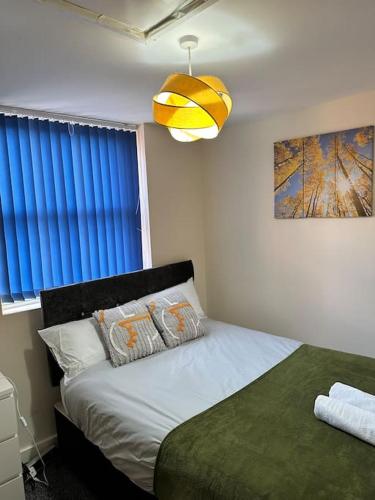 a bedroom with a bed and a pendant light at Airrose two bed apartment in Wolverhampton