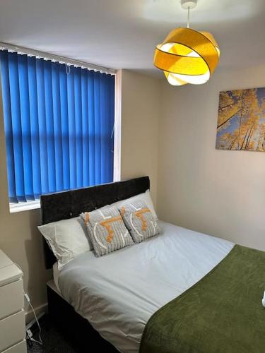 a bedroom with a bed with a blue window at Airrose two bed apartment in Wolverhampton