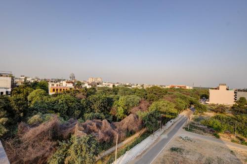 a road in a city with trees and buildings at Saltstayz Premier - Golf Course Road & Sector 42 in Gurgaon