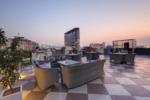 a rooftop patio with tables and chairs on a building at Saltstayz Premier - Golf Course Road & Sector 42 in Gurgaon
