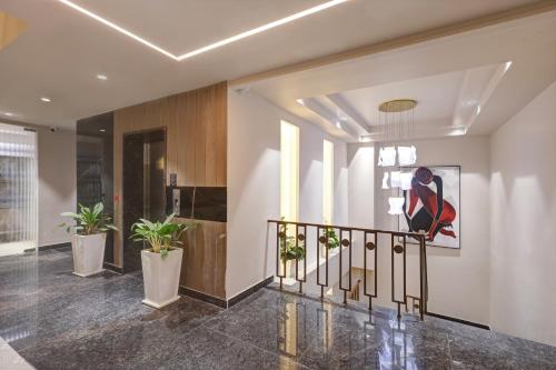 a hallway with a staircase with potted plants at Saltstayz Premier - Golf Course Road & Sector 42 in Gurgaon