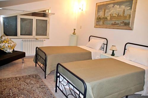 a bedroom with two beds and a couch at Vista Alcantara - Wellness Mountain-Top Retreat in Motta Camastra