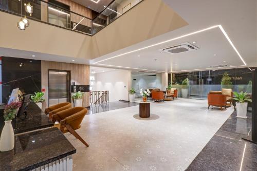 an empty lobby with chairs and tables in a building at Saltstayz Premier - Golf Course Road & Sector 42 in Gurgaon