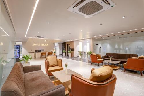 a lobby with couches and chairs in a building at Saltstayz Premier - Golf Course Road & Sector 42 in Gurgaon