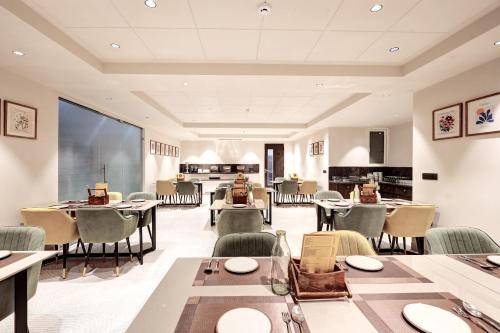 a large dining room with tables and chairs at Saltstayz Premier - Golf Course Road & Sector 42 in Gurgaon