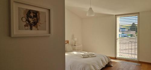 a white bedroom with a bed and a window at Wonderful cozy apartment very well located in Gross Gurmels