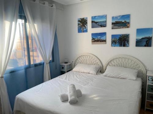 a bedroom with a white bed with towels on it at Espanhouse Sonia in La Zenia Playas de Orihuela in Orihuela