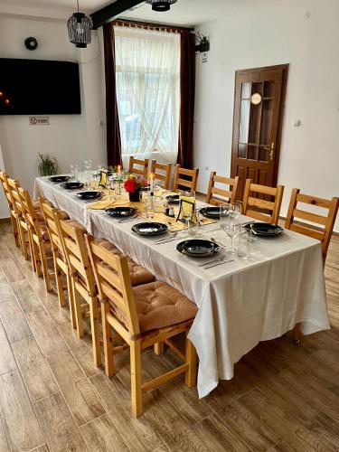 a dining room with a long table and chairs at Къща за гости Куклите Петревене in Petrevene
