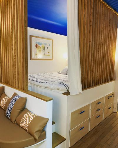 une petite chambre avec un lit et un canapé dans l'établissement Charme et haut standing - Vue sur La Défense, à Colombes