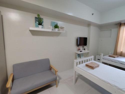 a small room with a bed and a couch at CozyNest Rentals at Brenthill Condominium in Baguio