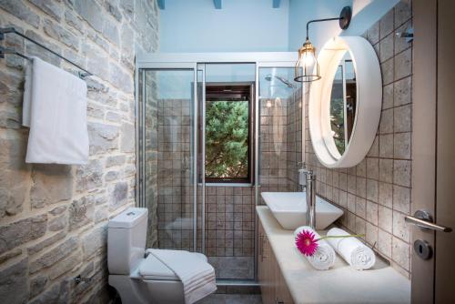 SívasにあるPhaistos Villas - Crete Poolside Luxury Retreatsの洗面台、トイレ、鏡のあるバスルーム