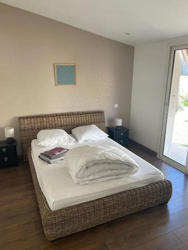 un lit avec deux livres et des oreillers dessus dans l'établissement Maison Mosse, à Angoulins-sur-Mer