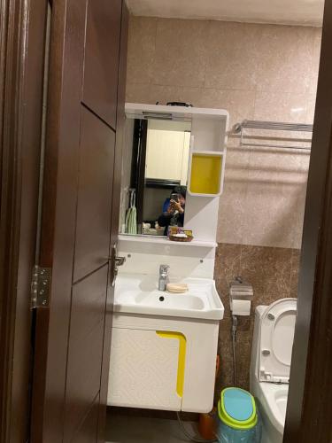 a bathroom with a sink and a mirror and a toilet at Arkes Residential Condo Unit Rental in Baguio
