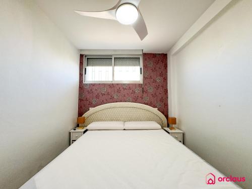 Un dormitorio pequeño con una cama y una ventana. en El Alba, en Benicàssim