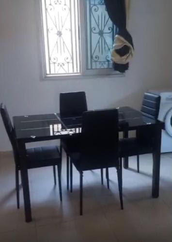 a black dining room table with chairs and a laptop at Villa Amina splendid elegant structure in Ouagadougou