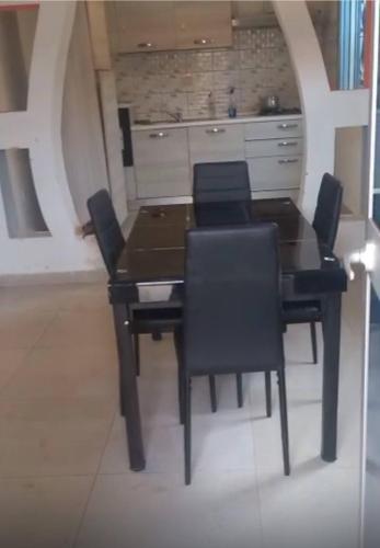 a dining room with a table and black chairs at Villa Amina splendid elegant structure in Ouagadougou