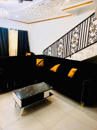 a living room with a black couch and a coffee table at Villa Amina splendid elegant structure in Ouagadougou