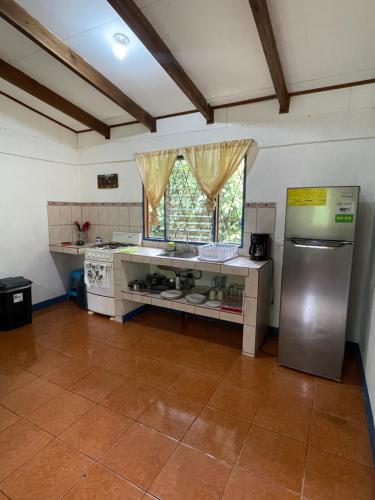 a kitchen with a stainless steel refrigerator and a window at Cabinas Caribe Luna in Cahuita