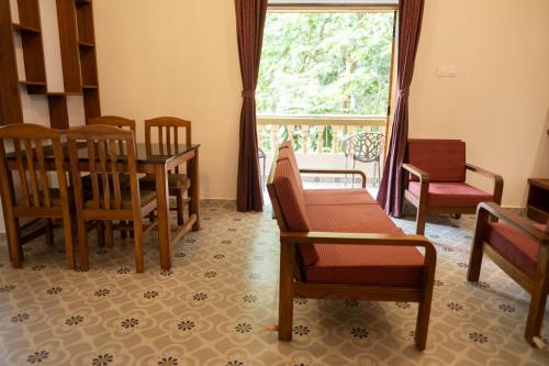 a dining room with a table and chairs and a window at Vistar Holidays in Goa