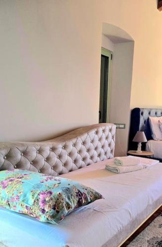 a bed with a tufted headboard in a bedroom at Vista Del Mar Mansion in Spile
