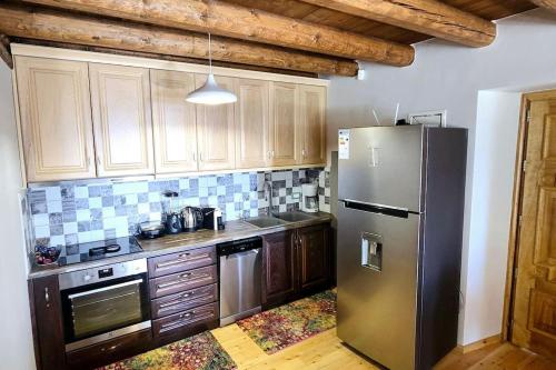 a kitchen with a stainless steel refrigerator and wooden cabinets at Vista Del Mar Mansion in Spile