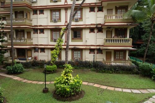 a large building with a garden in front of it at Vistar Holidays in Goa