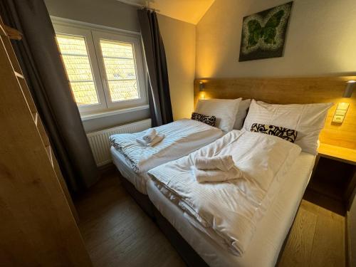 a bedroom with two beds with towels on them at Apartmány Formanka na náměstí in Hustopeče