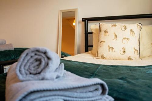 a bedroom with a bed with a towel on it at Augusta House - Andover in Enham-Alamein