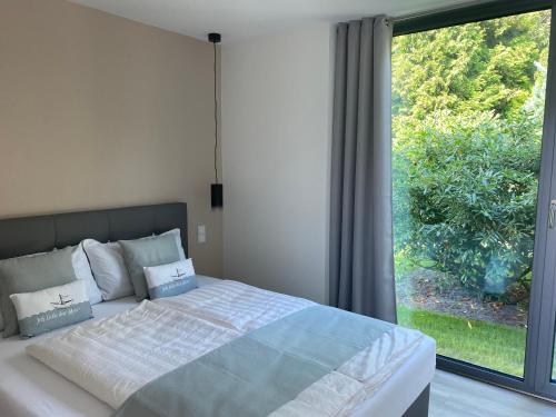 Happynest في زنغست: غرفة نوم بها سرير ونافذة كبيرة