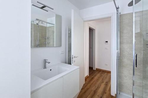 a white bathroom with a sink and a shower at Monolocale centro storico in Novara