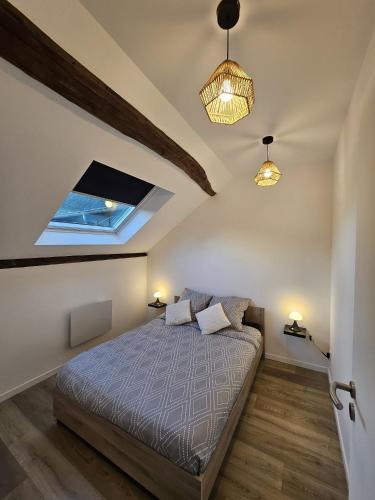 une chambre avec un lit et deux lampes et une fenêtre dans l'établissement Joli appartement mansardé, à Decize