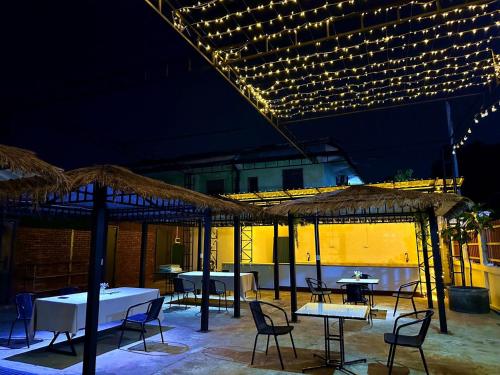 a patio with tables and chairs and lights at Venn Hostel in Vientiane