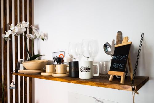 a shelf with dishes and utensils on it at Central ZEN apartament in Cluj-Napoca