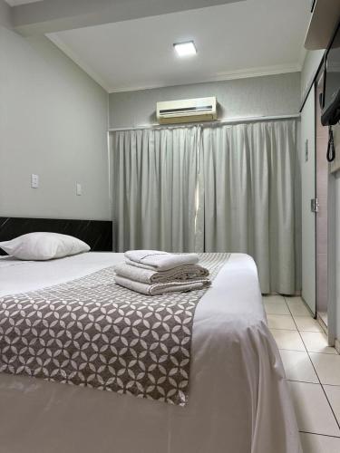 a bedroom with a bed with towels on it at Hotel Boituva Inn - Your Hotel in Boituva