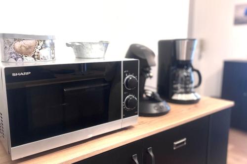 a microwave sitting on top of a counter with two blender at Studio Confortable en plein centre Metz in Metz