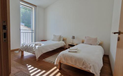 a white room with two beds and a window at Wonderful cozy apartment very well located in Gross Gurmels