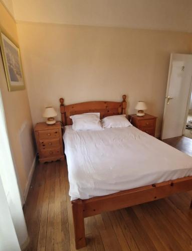 - une chambre avec un lit doté de draps blancs et de 2 tables de nuit dans l'établissement Gîte de la bergerie, à Châtellerault