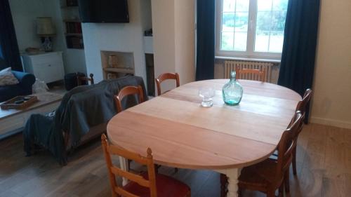 a wooden table in a living room with a bottle on it at Ploubalay Chambres Cuisine Séjour in Ploubalay