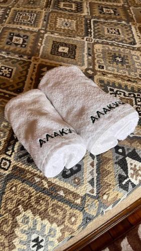 a pair of towels with the word mind on them on a bed at Ethno complex Ala kuch in Kaindy