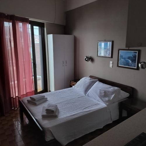 a bedroom with a bed with two towels on it at Bissias Guest House in Galatas