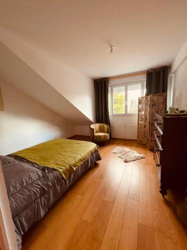 une chambre avec un lit, une fenêtre et une chaise dans l'établissement Appartement 200m de la plage, à Hauteville-sur-Mer