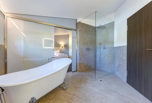 a bathroom with a bath tub and a shower at Hotel am Kurpark in Zinnowitz
