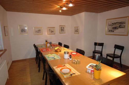 a dining room with a long wooden table and chairs at Hotel Pension Im Dorf in Zuzwil