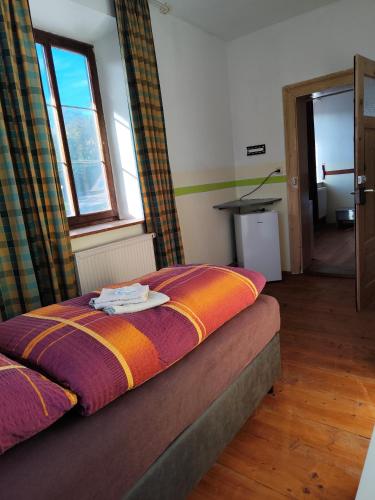 a bedroom with a bed with an orange and purple blanket at Mama Leone in Weihenstephan