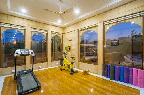a gym with a treadmill in a room with windows at The Gulaal in Jaisalmer