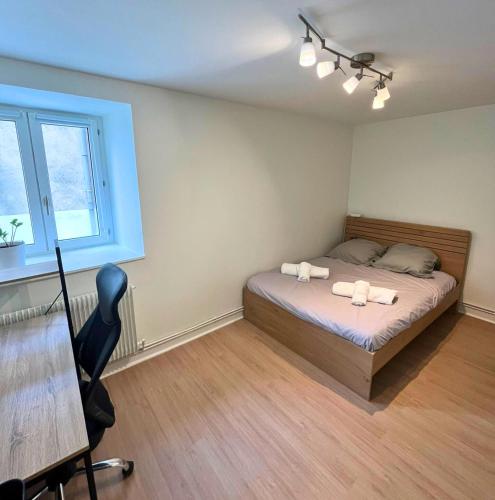 une chambre avec un lit, un bureau et une fenêtre dans l'établissement Halle aux Blés- Appartement au Centre Historique, à Bourges