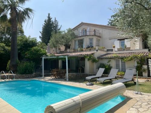 une piscine devant une maison dans l'établissement Belle villa de charme avec piscine, à Tourrettes
