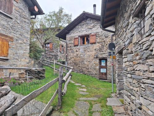 a stone building with a fence in front of it at I viaggi del Lea in Cadenazzo