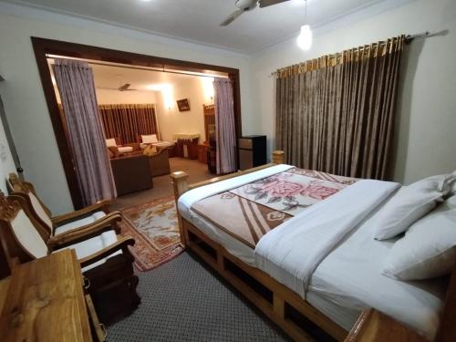 a bedroom with a bed and a living room at Alaf Laila Guest House in Abbottābād
